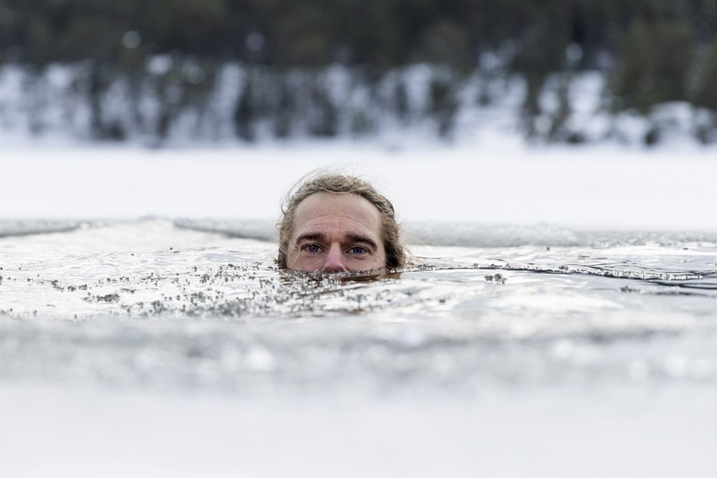 En man badar i en isvak. Henrik Trygg.