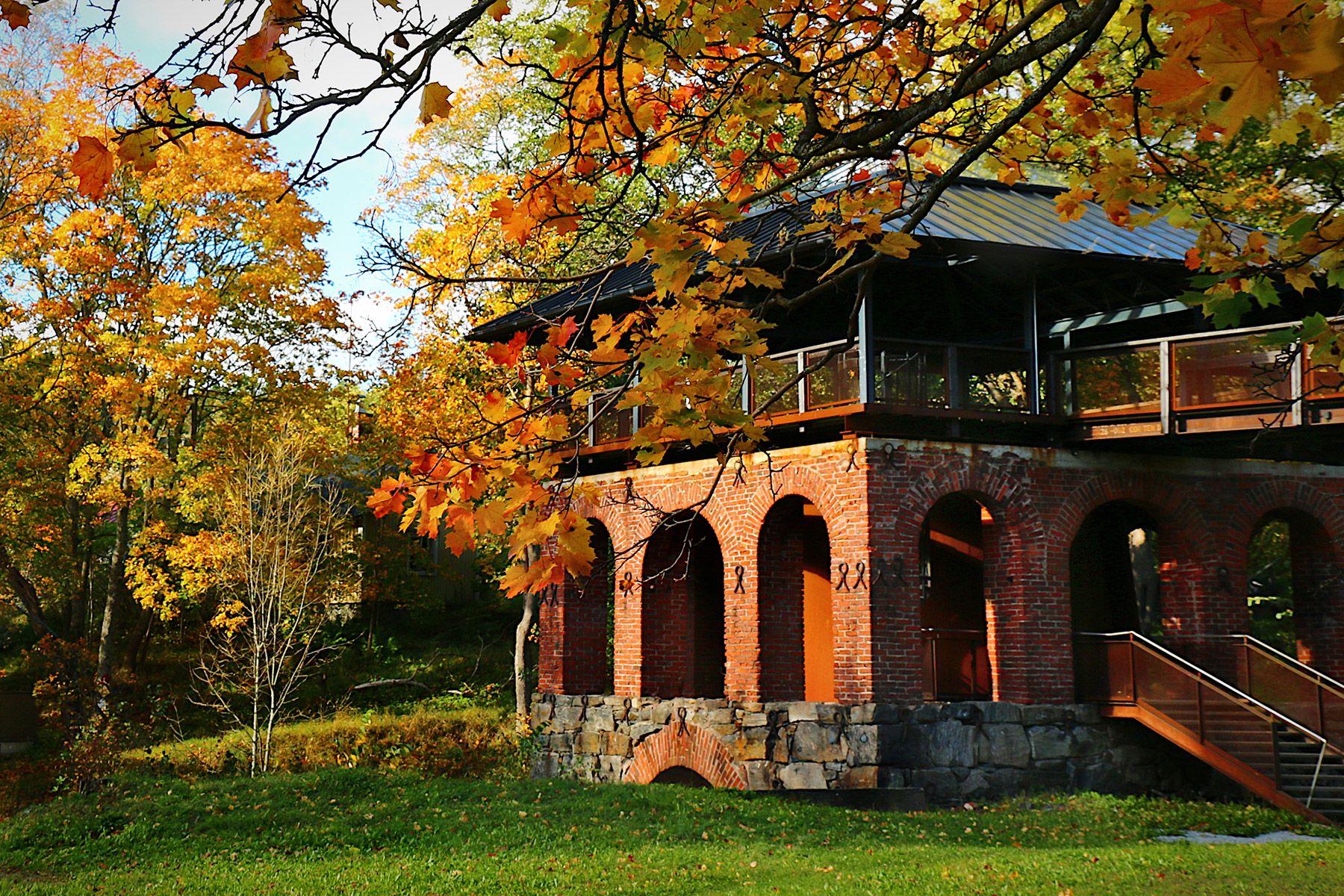 An old building in Dalsbruk surrounded by trees in autumn.