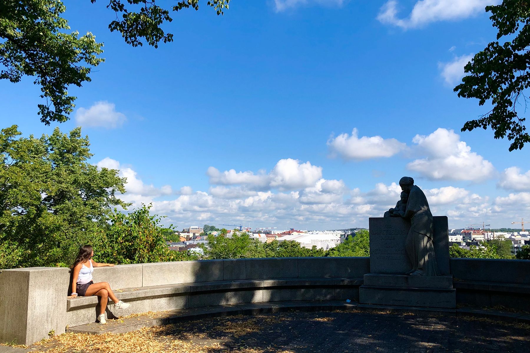 A person sits on the 11-metre wide concrete arch, part of the G. A. Petrelius monument, and looks towards the city.