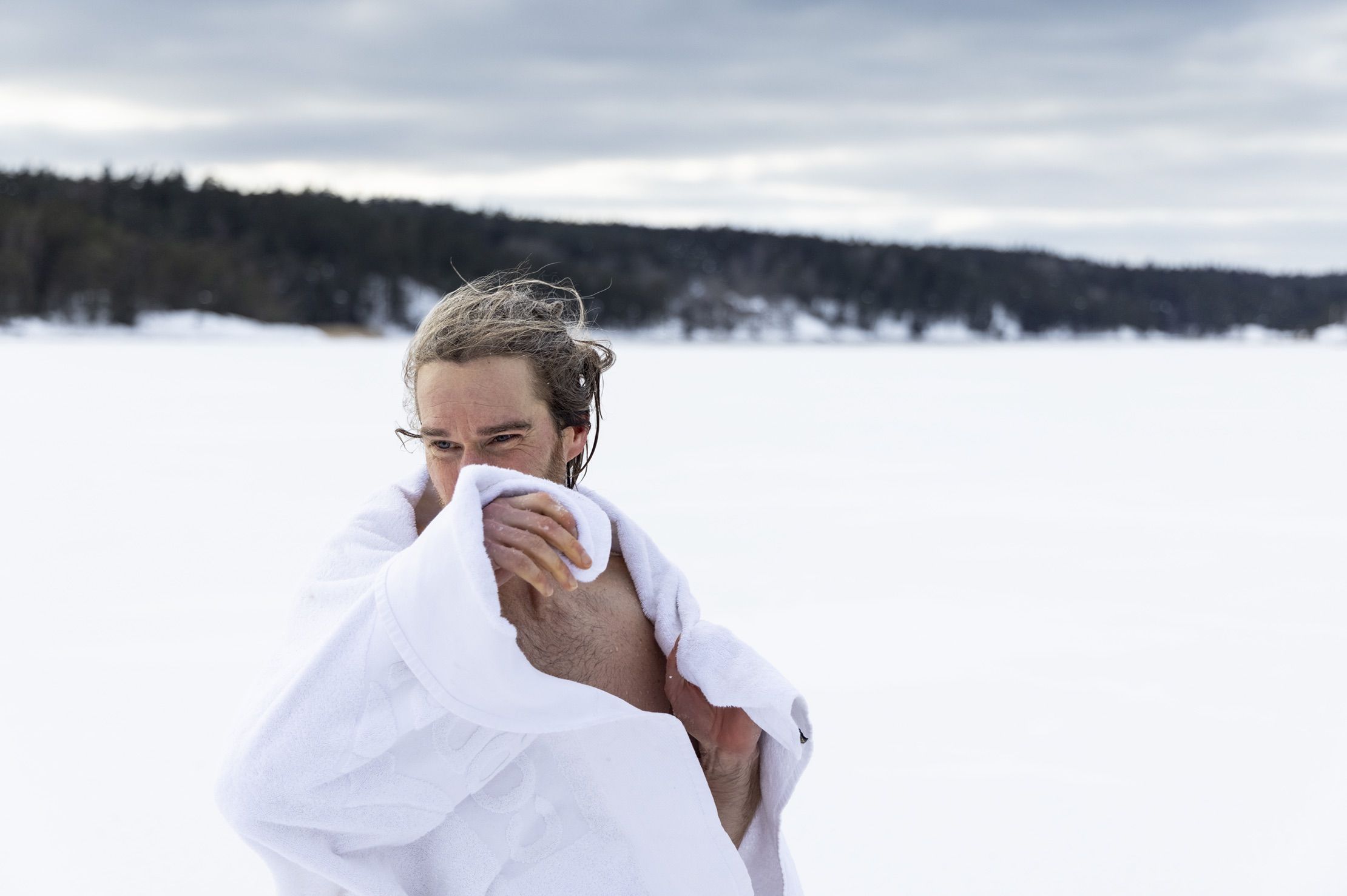 En man torkar sig med handduk efter ett bad i en isvak. Foto: Henrik Trygg.