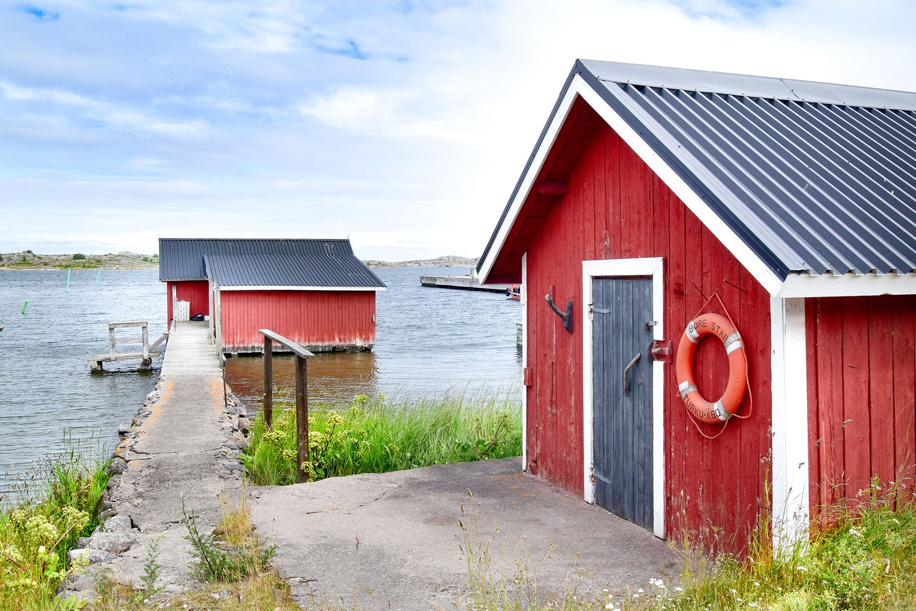 Red wooden buildings beside the sea on the island of Utö.