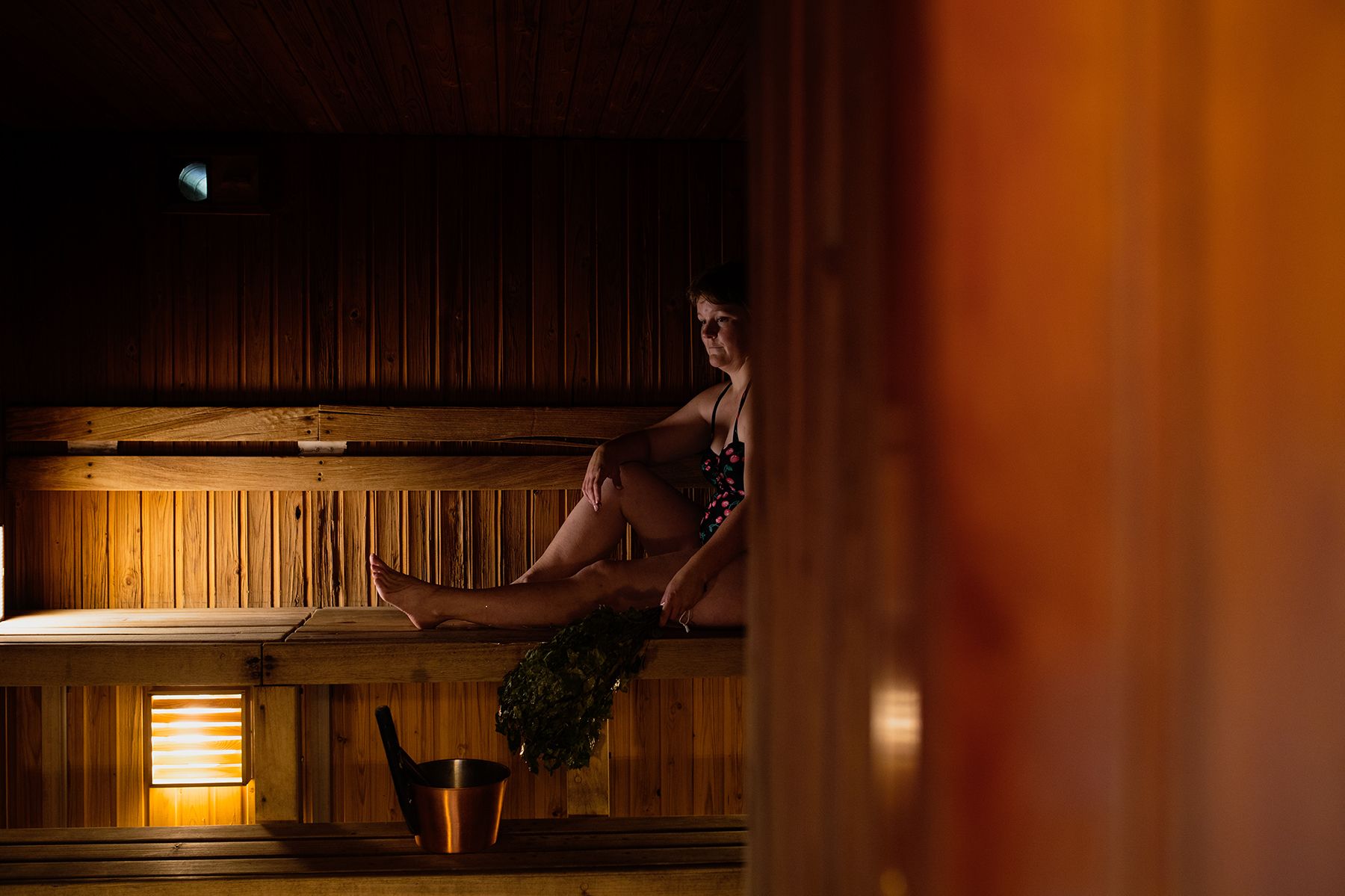 A woman sits inside a sauna on Örö Fortress Island.