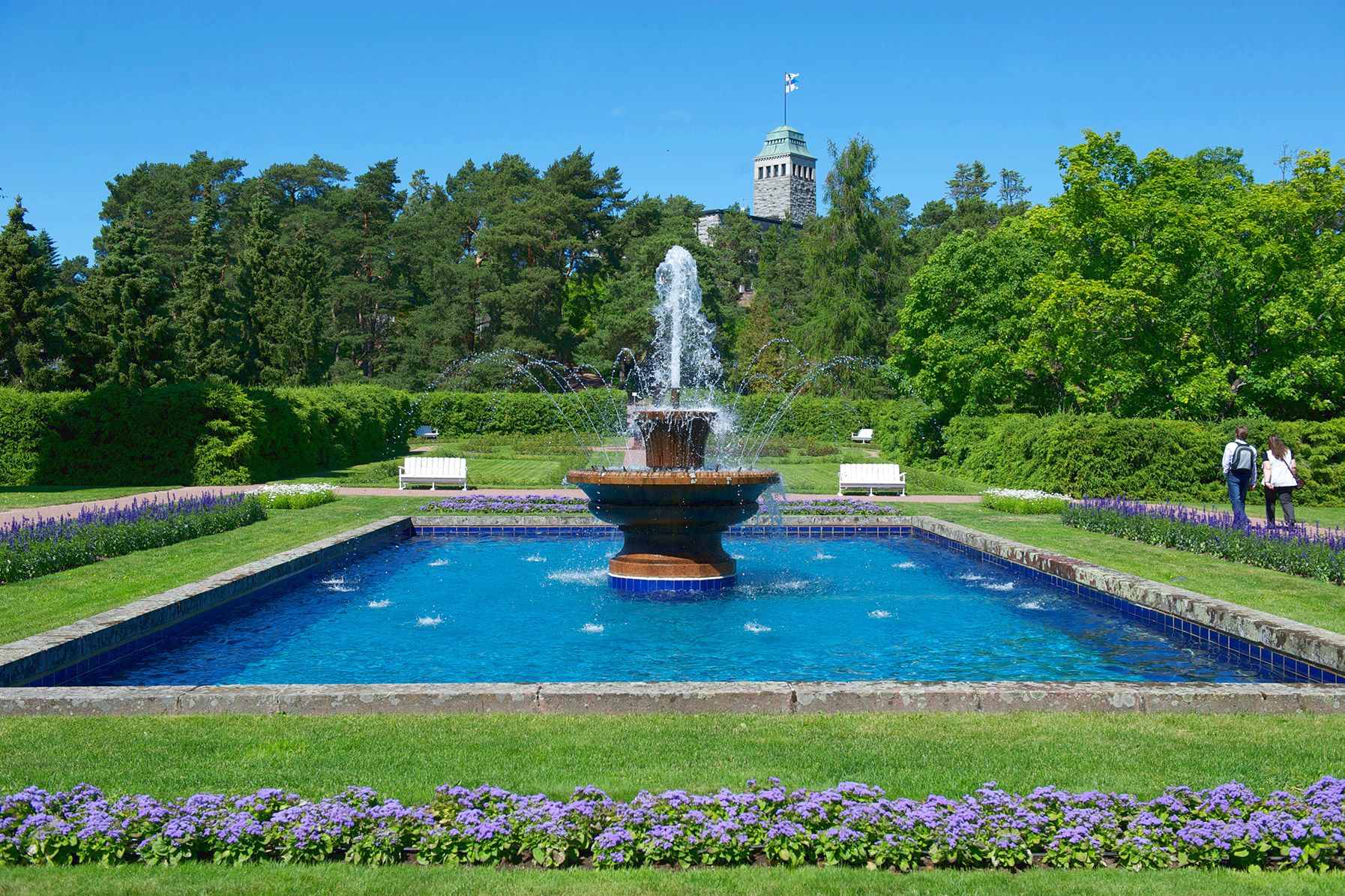 Visitors walk by a fountain in the Kultaranta garden.