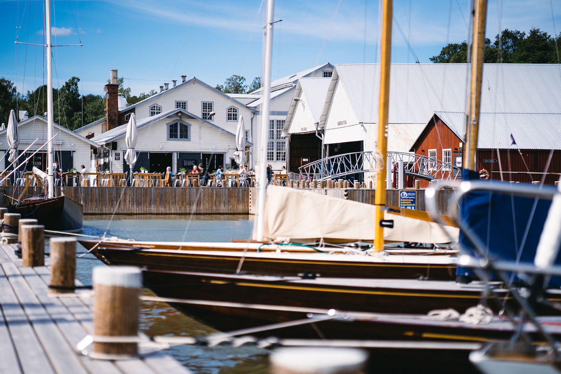 Ruissalo Boatyard on a summer's day with boats docked in the harbour and diners enjoying a meal at Zake Pizzeria & Wine Bar.