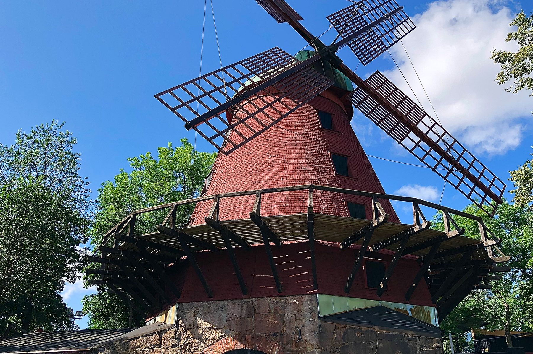 Samppalinna’s red wooden windmill, surrounded by green trees.