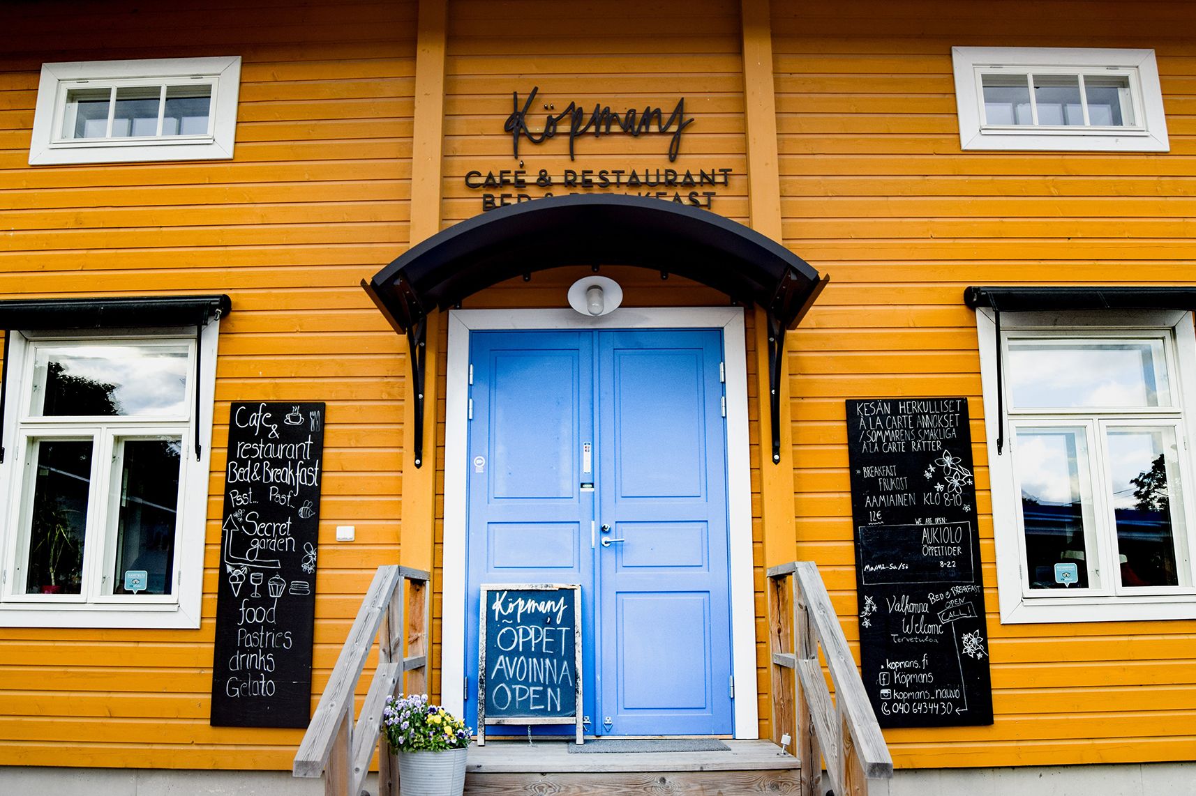 The yellow building of Köpmans with a blue front door.