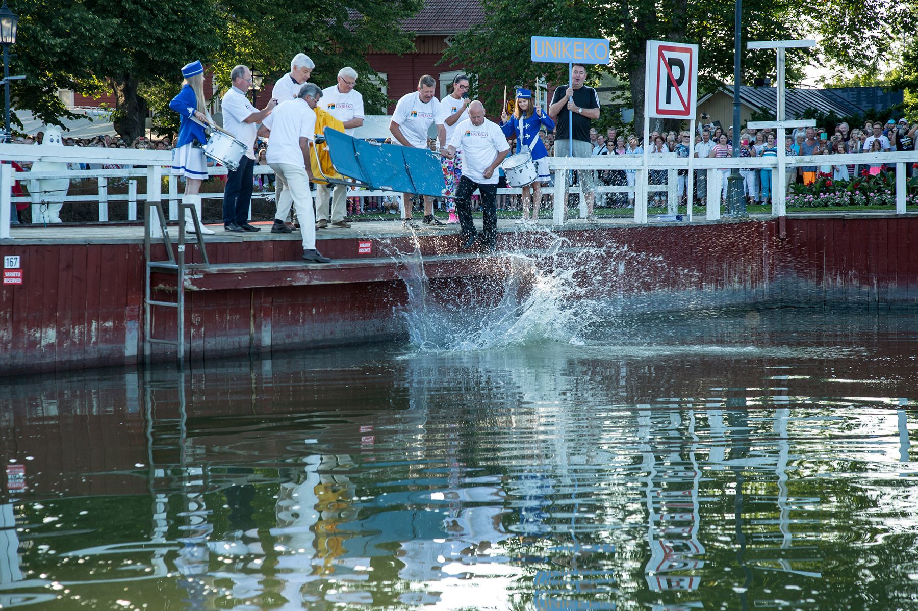 Visitors look on as a person is a thrown from their bed into the water in Naantali.