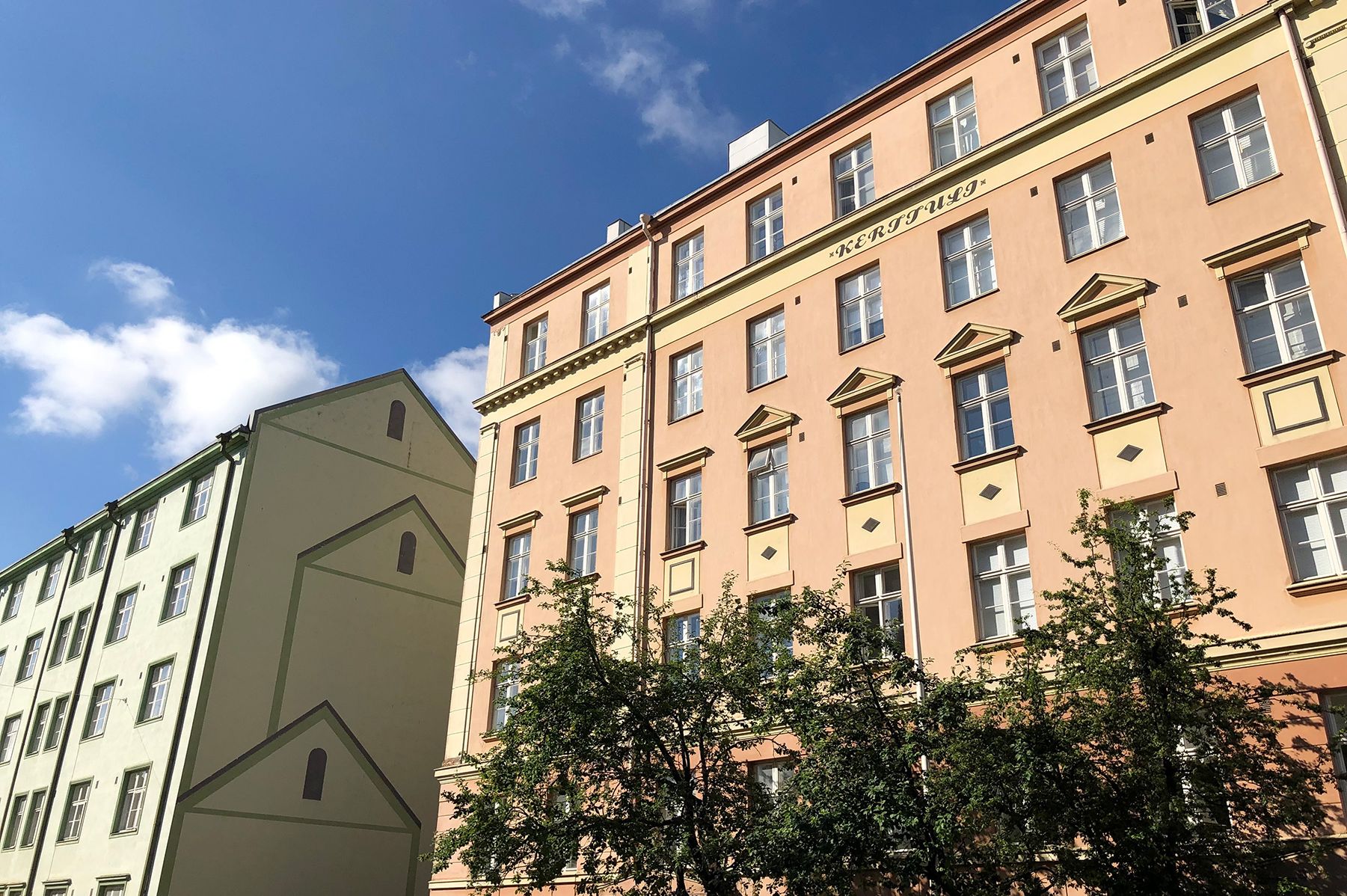 The neoclassical, multi-storey, green and peach-coloured buildings on Sirkkalankatu Street in the sunshine.